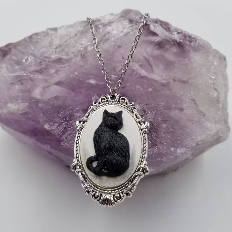Cameo necklace with a black cat design on a white background and silver chain