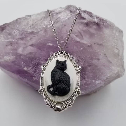 Cameo necklace with a black cat design on a white background and silver chain