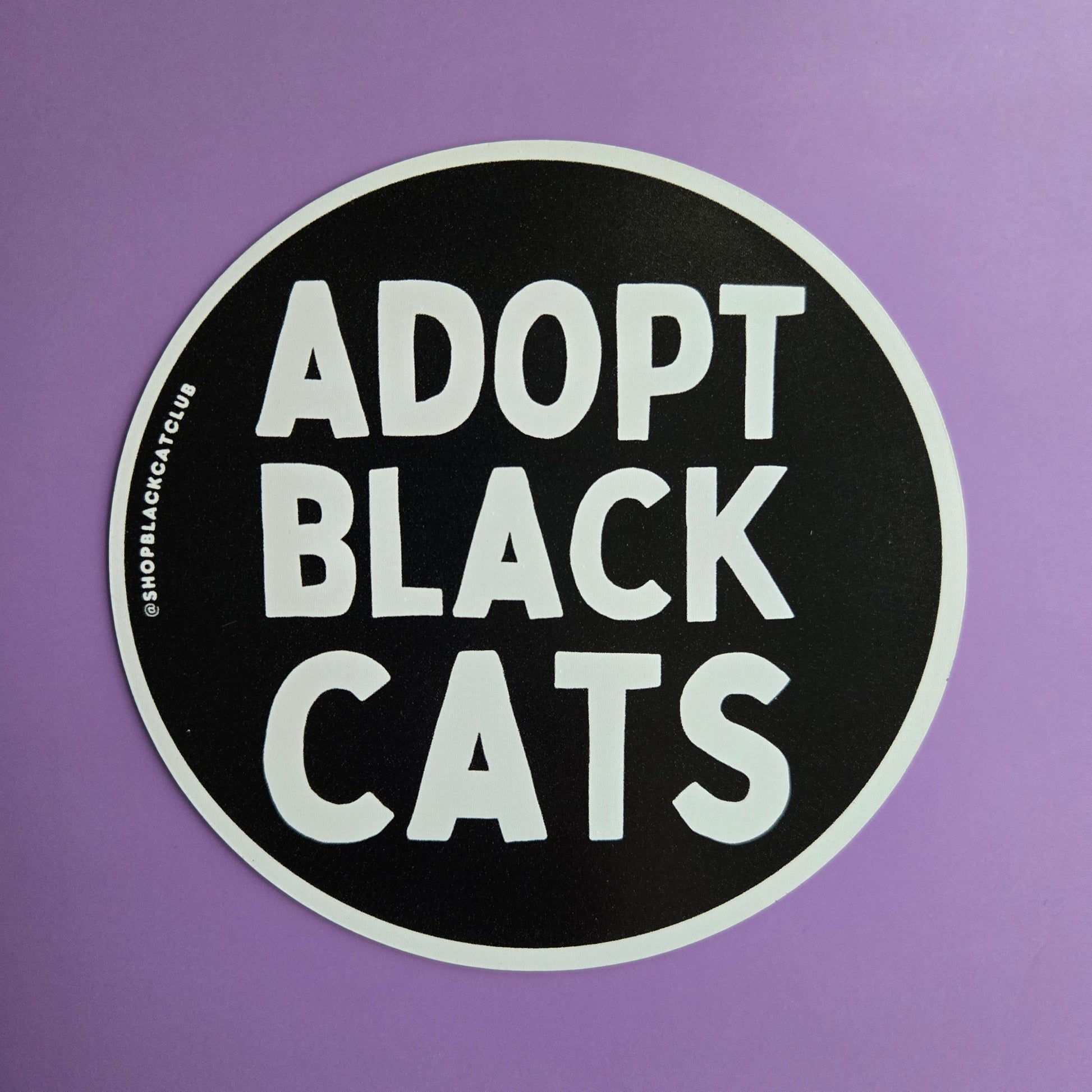 Round magnet with 'Adopt Black Cats' in white text on a black background