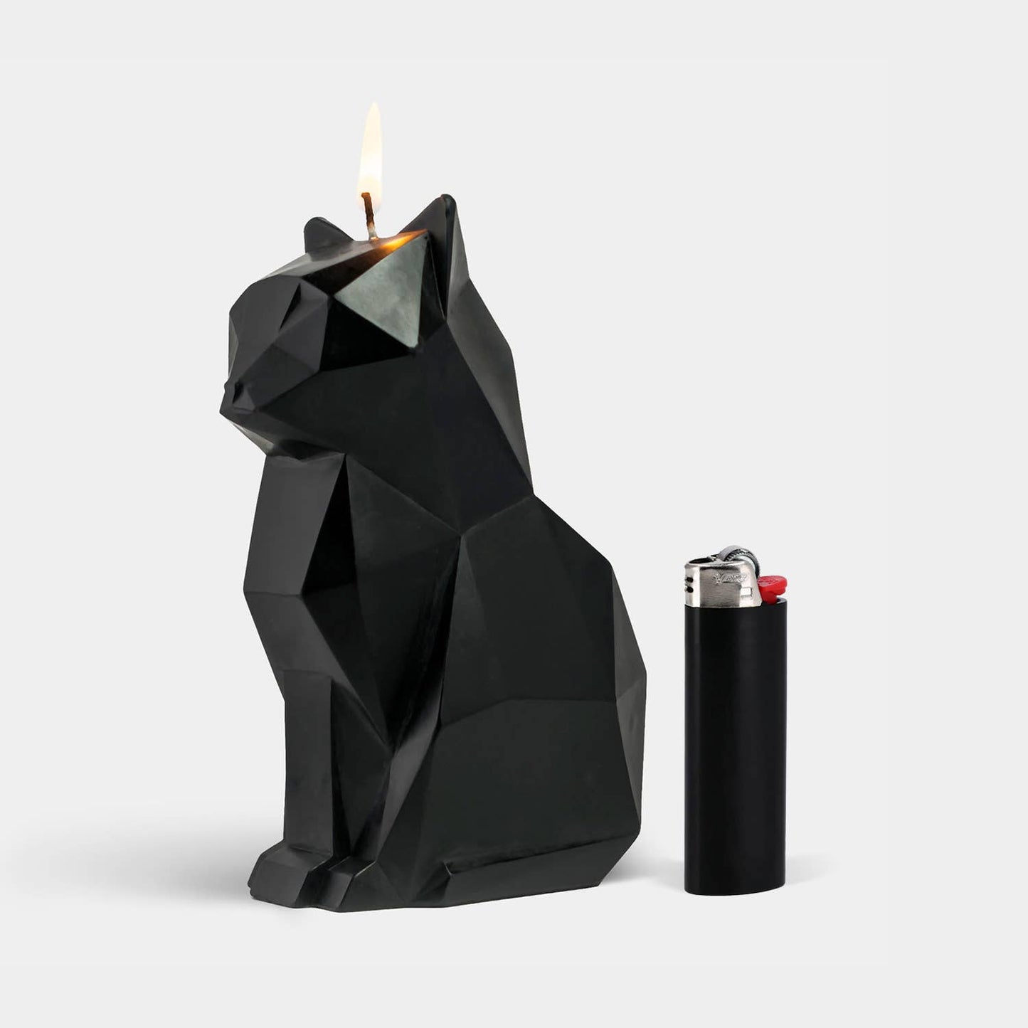 Black cat shaped candle on a white background sat next to a black Bic lighter to demonstrate size