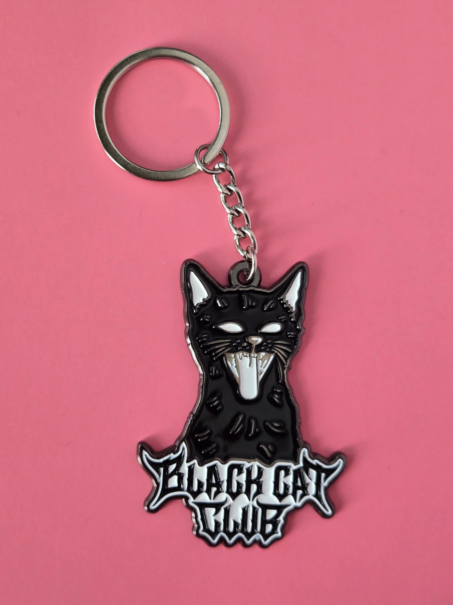 Black cat-shaped keychain with 'Black Cat Club' text on a pink background