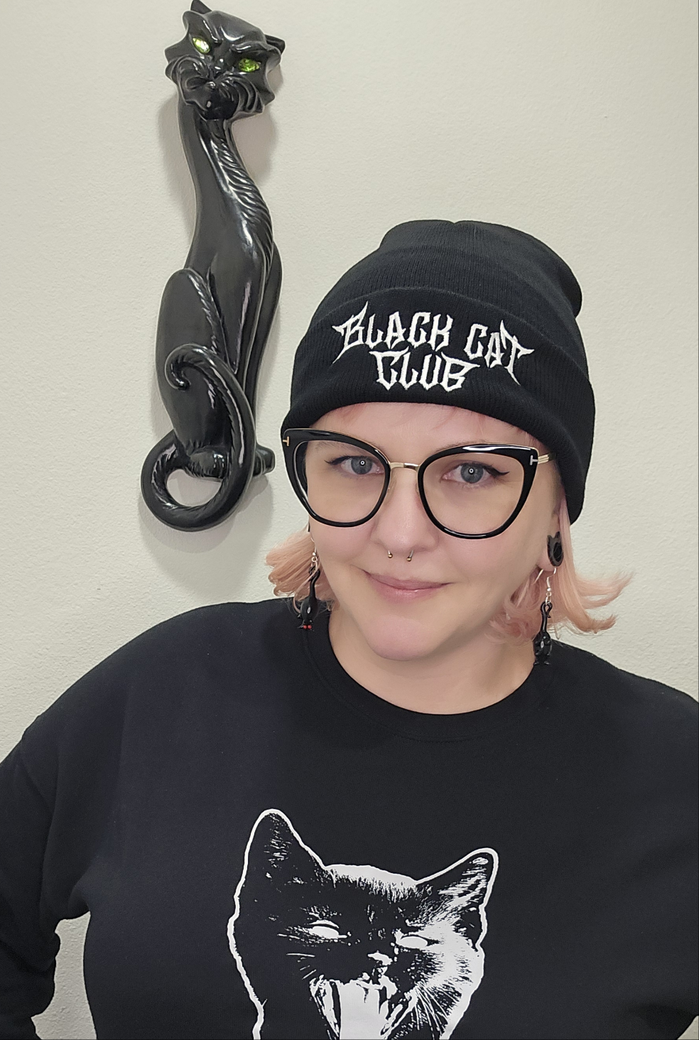 Woman wearing Black beanie with 'Black Cat Club' logo embroidered in white on the cuff.