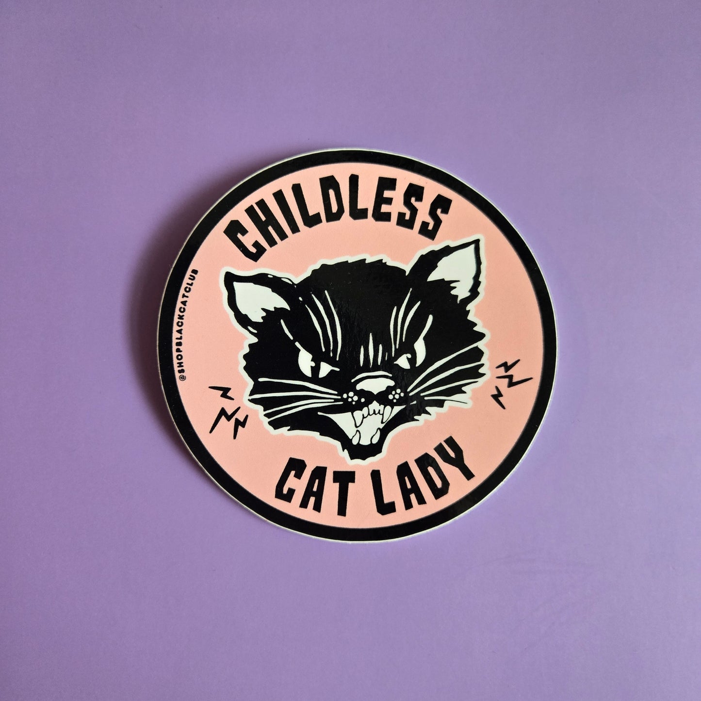 A round sticker with a black cat design and the text 'Childless Cat Lady' on a pink background.