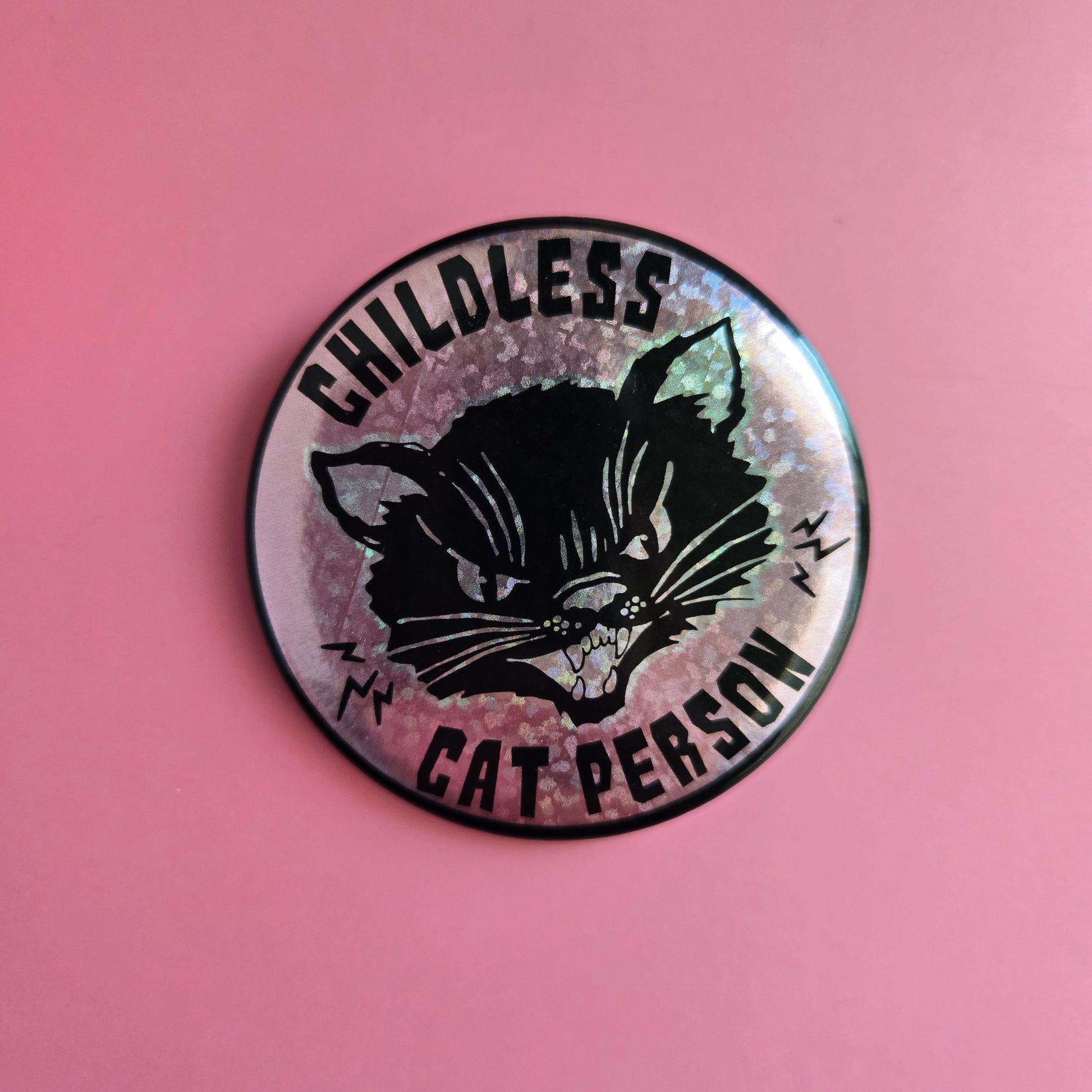 Round button with text 'Childless Cat Person' on a pink sparkle background, featuring a black cat.