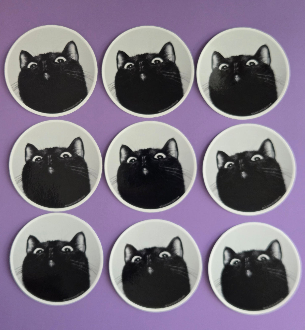 Nine circular stickers with black cat photo on a purple background