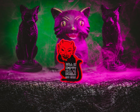 A sticker depicting a red devil cat with the text 'Hell is Empty and all the Devils are Here' with a vintage Halloween black cat in the background with a purple hue.