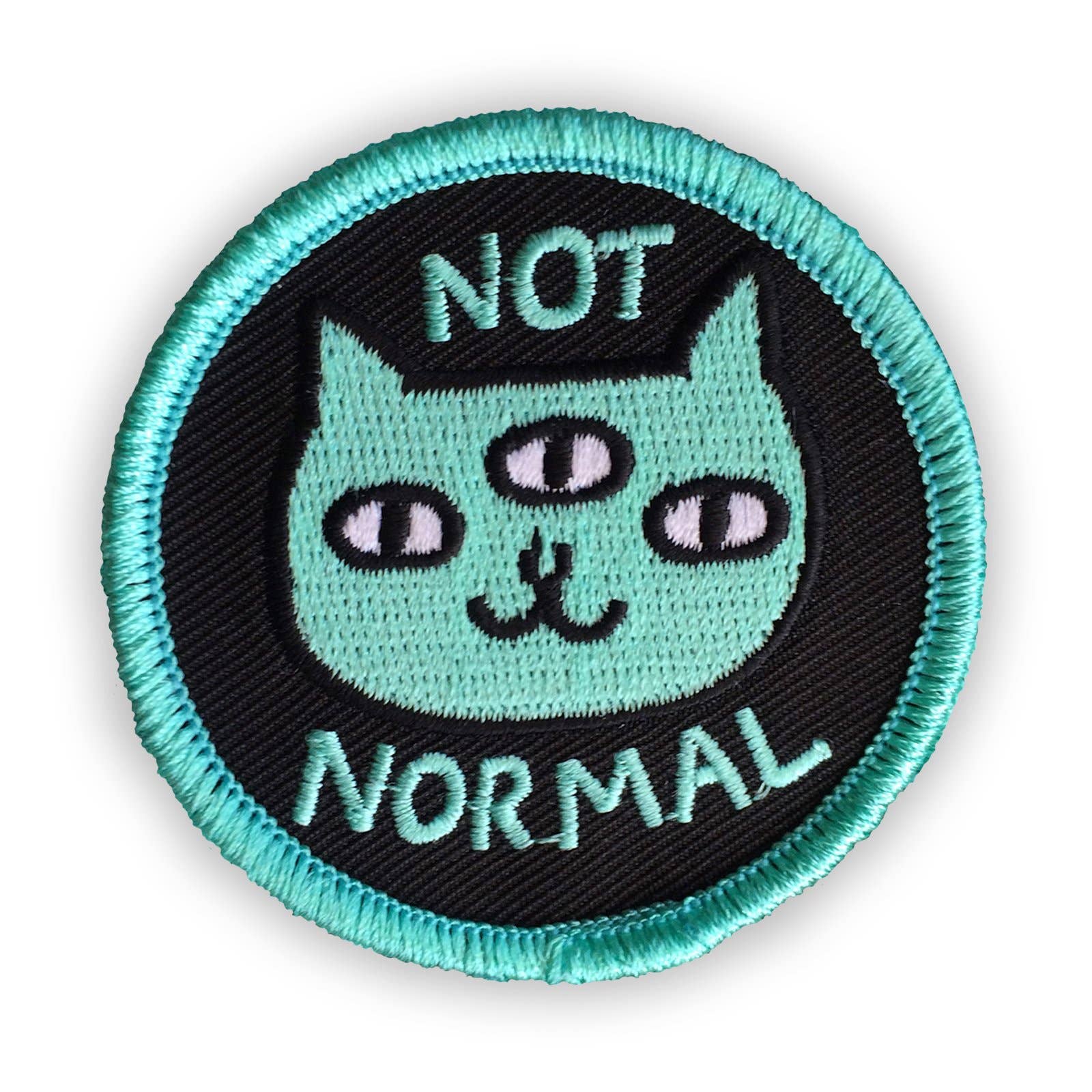 Circular patch with a cat illustration and 'Not Normal' text on a black background