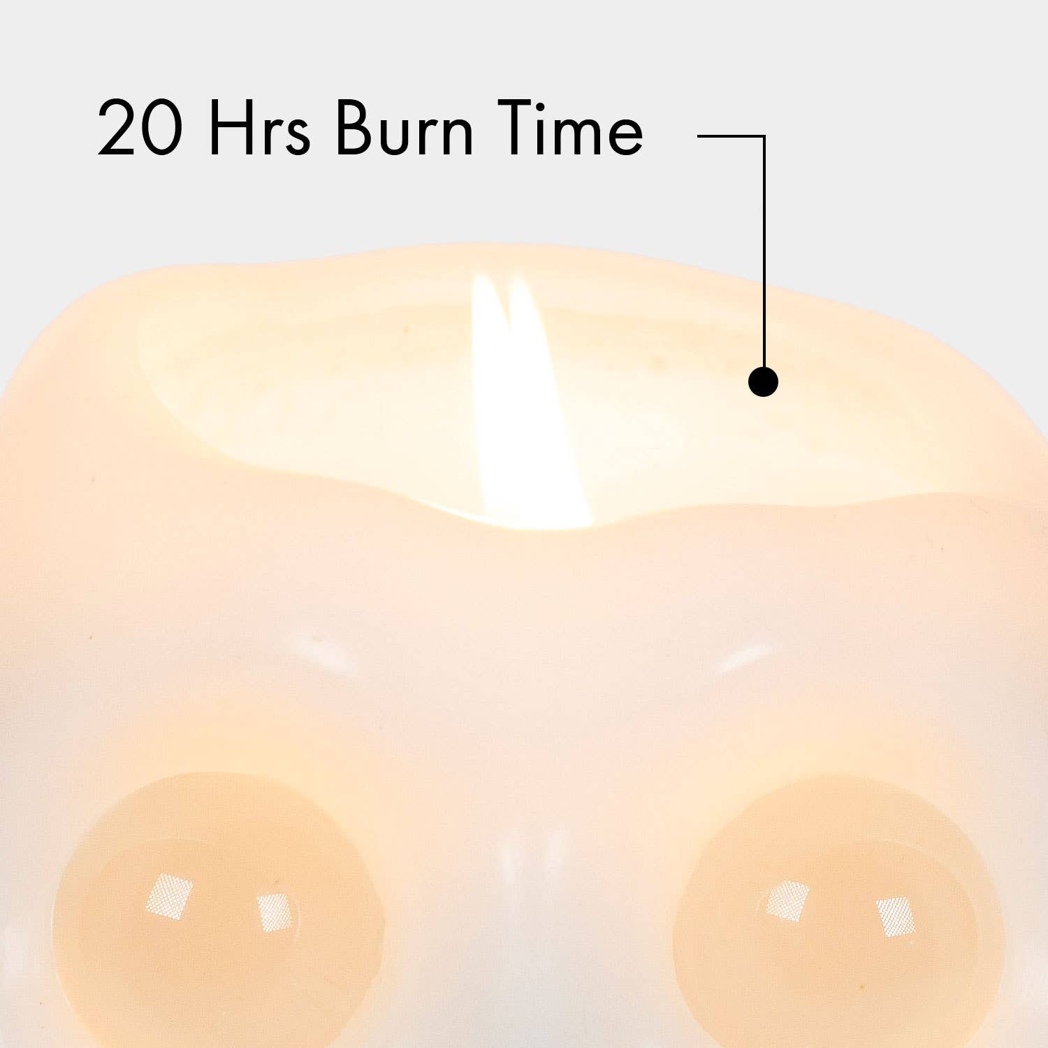 Close-up of a lit cream-colored candle with a flame and overlaid text reading '20 Hrs Burn Time' pointing to the wax surface.