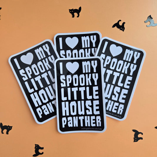 Three rectangular stickers with rounded corners displayed on an orange background. The stickers are black with white text reading 'I ♥ MY SPOOKY LITTLE HOUSE PANther' and are decorated with small black cat and witch silhouettes scattered around.