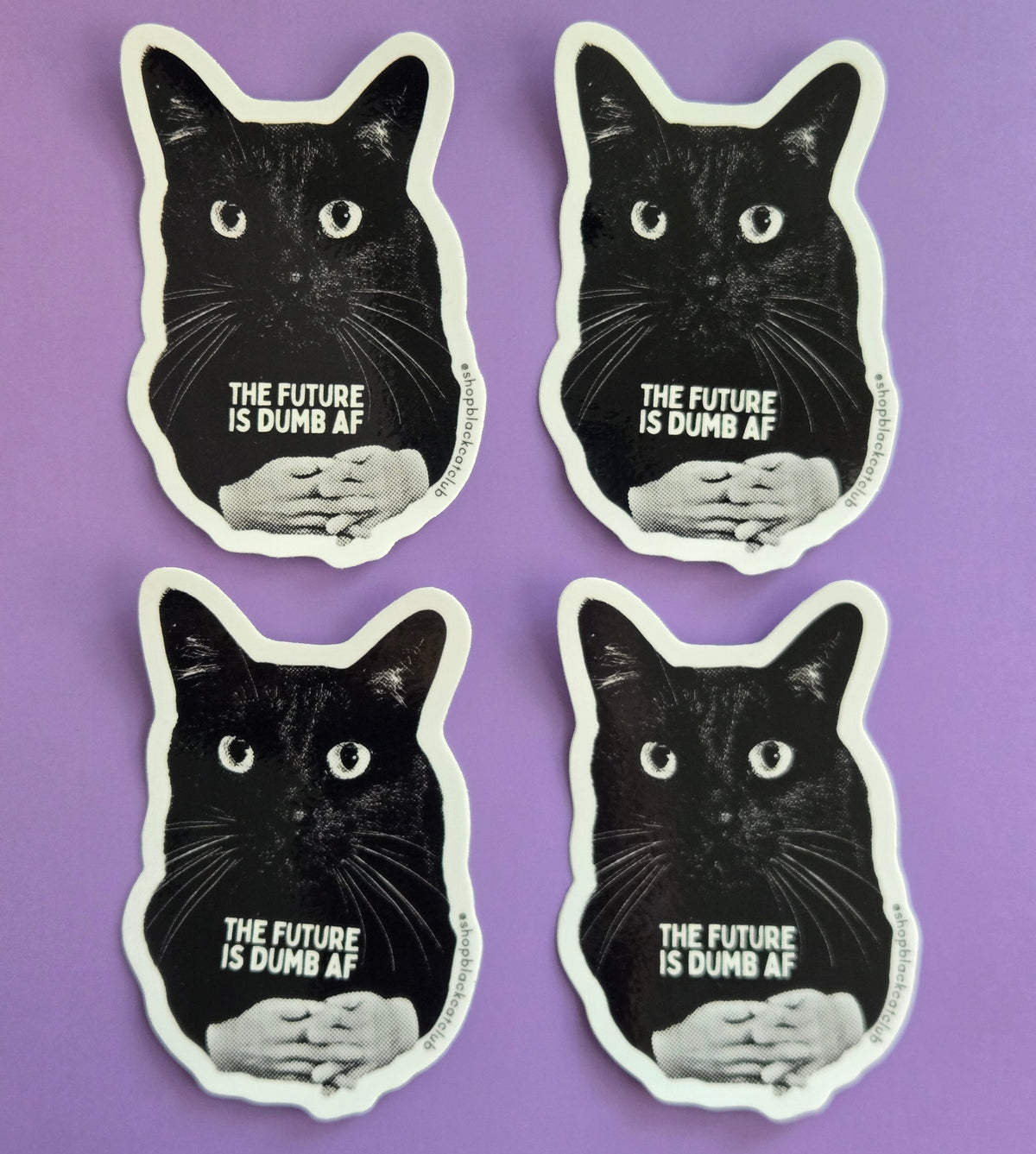 Black cat-shaped sticker with text 'THE FUTURE IS DUMB AF" on a purple background