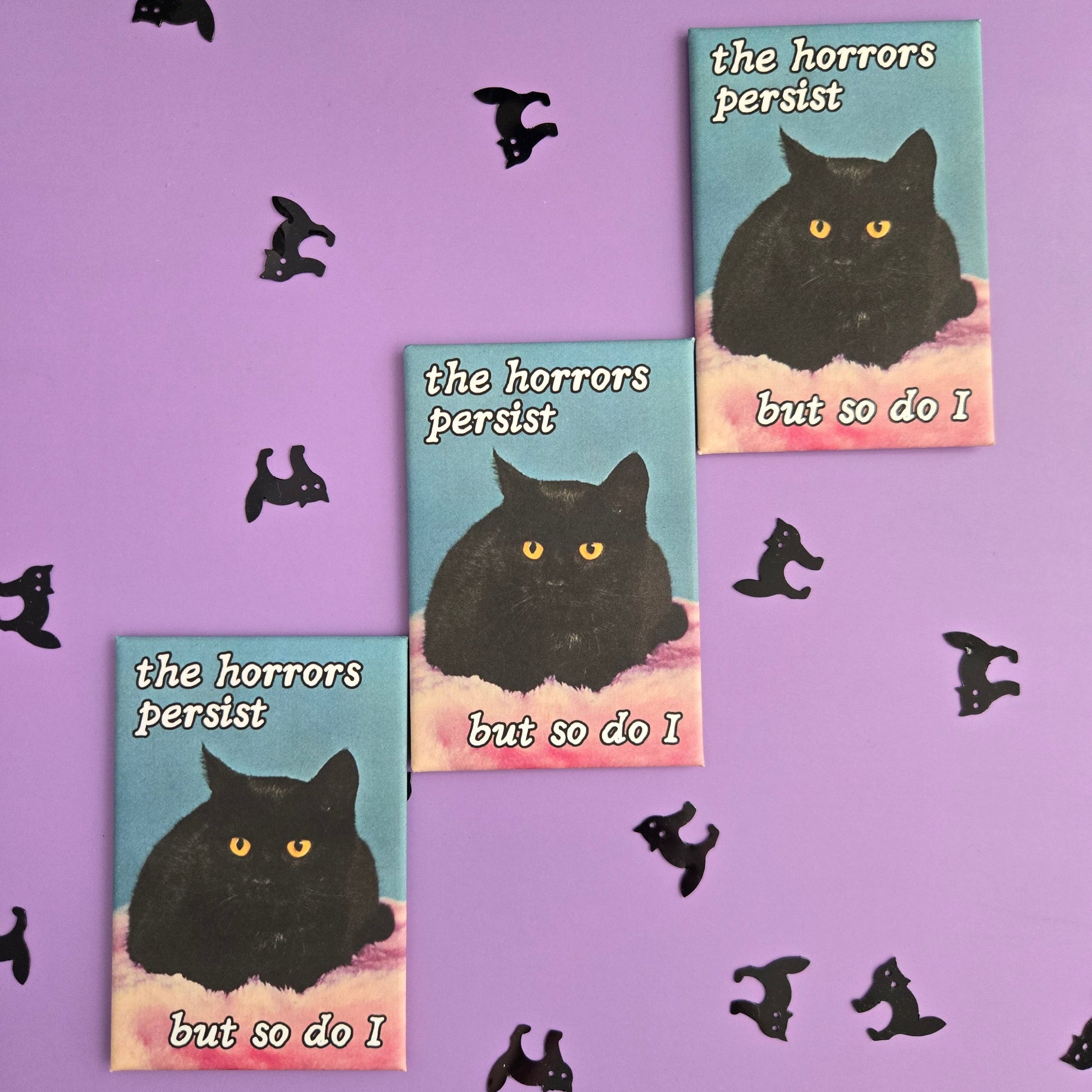 3 rectangular magnets with vintage black cat photo and text reading The Horrors Persist But so Do I displayed on a purple background with black cat confetti.