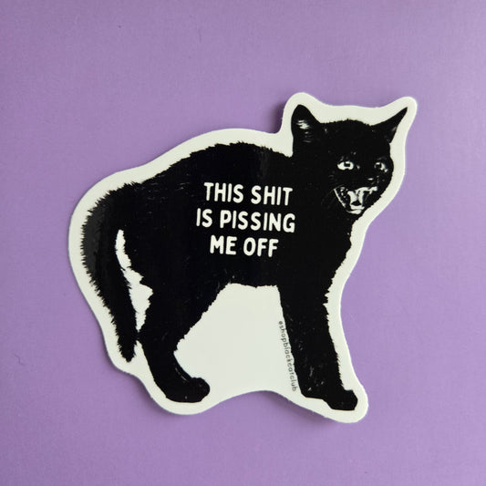 A sticker with a black cat design and the text 'This Shit Is Pissing Me Off' on a purple background.