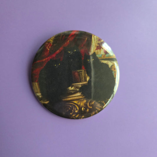 Round button with decorative with intricate design of Carl Kahler's painting '3 black cats', on a purple background